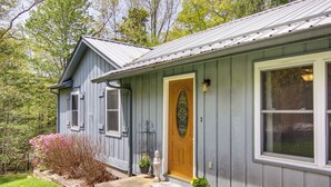 A house with a wooden door, a welcome mat, and potted plants. - Pet-friendly Black Mountain Vacation Home w/ Deck (Black Mountain)