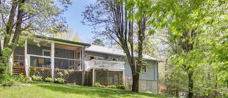 A two-story house with a covered porch and a fenced backyard.