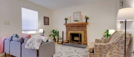 A living room with a fireplace, a sofa, a chair, and a floor lamp.