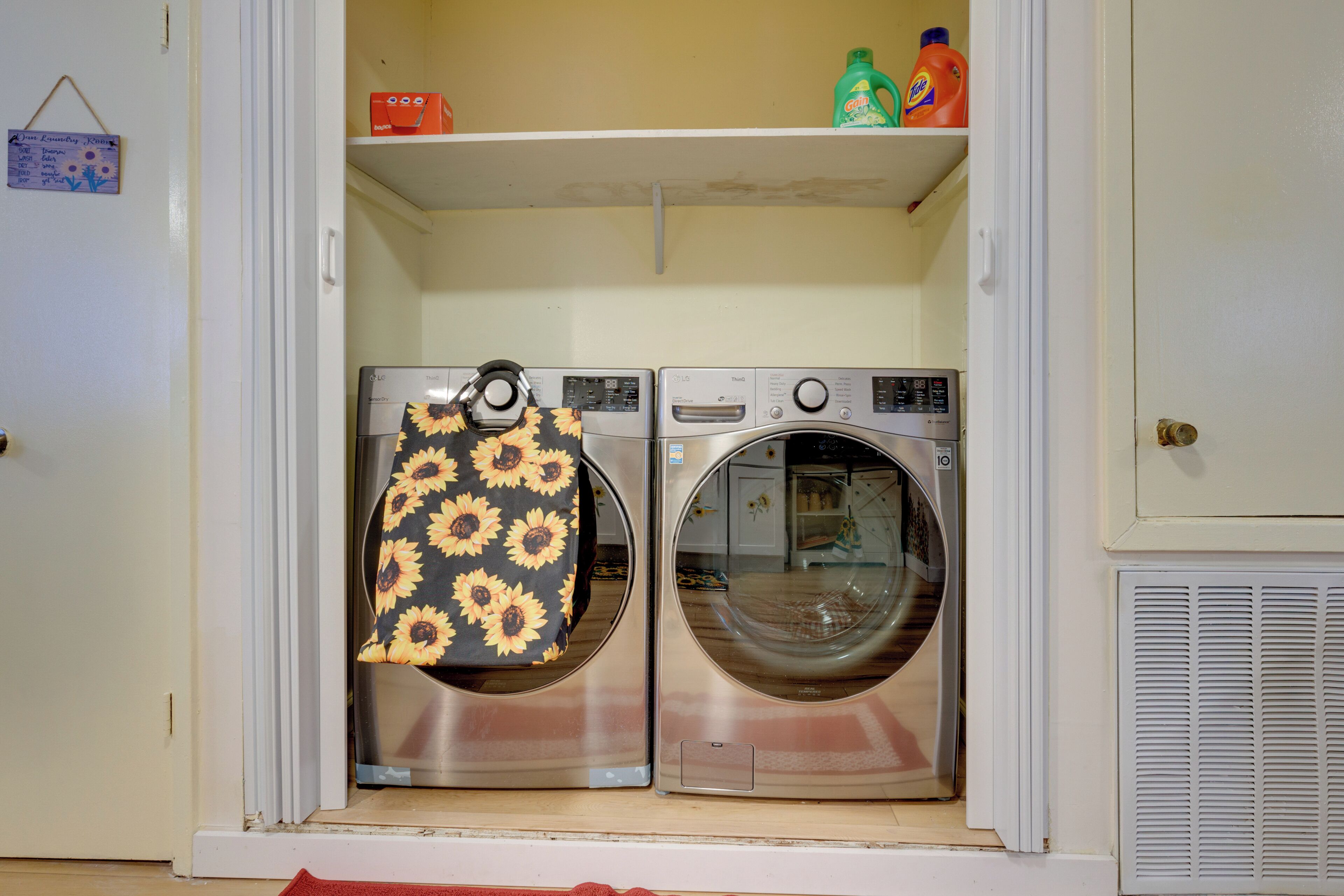 A laundry room with two front-loading washing machines and a dryer.