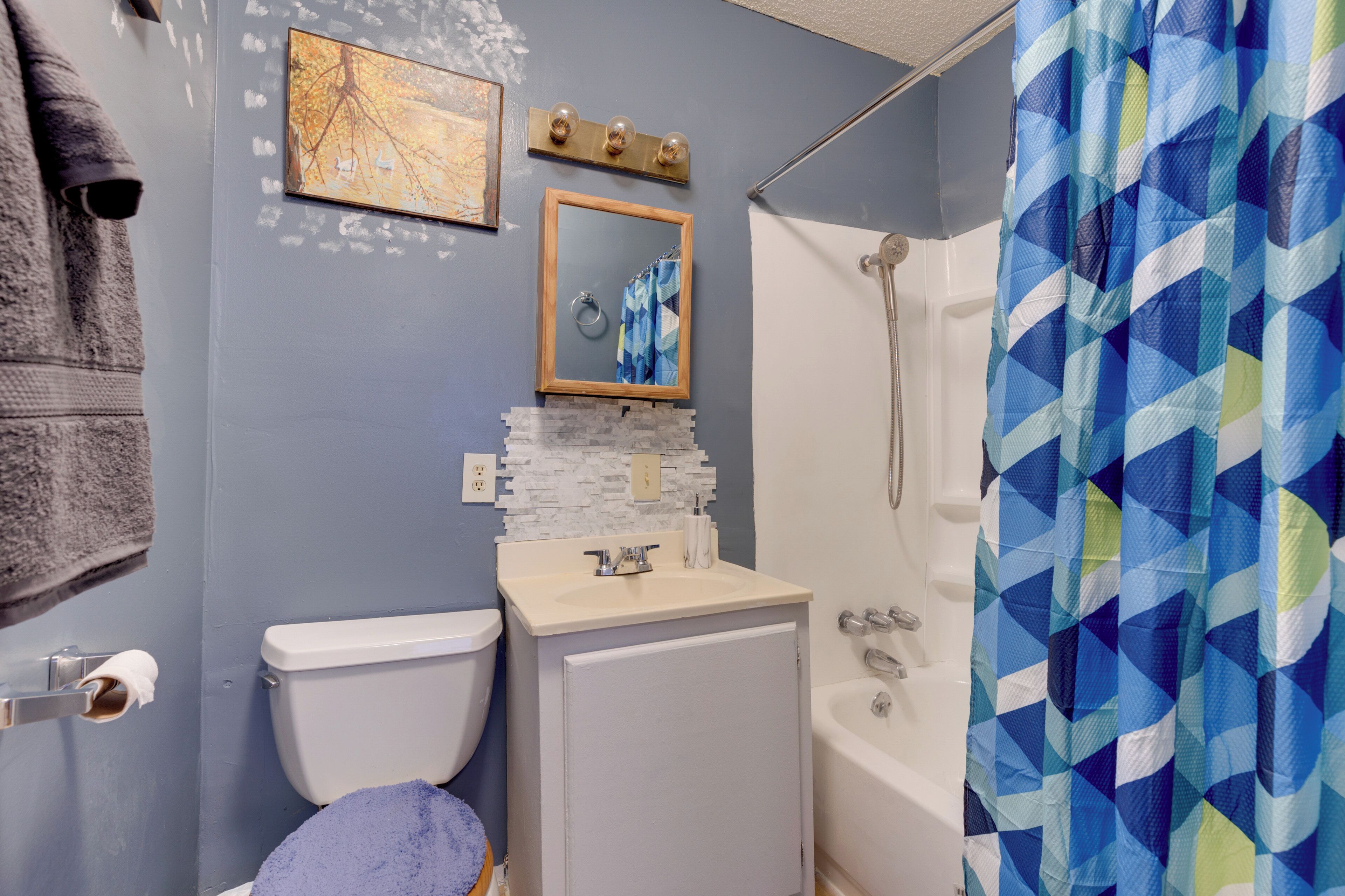 A bathroom with a toilet, sink, and shower.