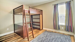 A room with a bunk bed, a ladder, a window with striped curtains, and a gray rug. - Pet-friendly Home w/ Pool, 25 Mi to Austin! (Leander)