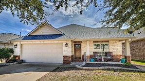 A two-story house with a garage, a front porch with a bench, and a brick exterior. - Pet-friendly Home w/ Pool, 25 Mi to Austin! (Leander)
