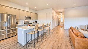 A modern kitchen with stainless steel appliances, a central island with bar stools, and a wooden floor. - Flagstaff Retreat w/ Covered Patio, 3 Mi to Dtwn (Flagstaff)