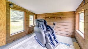 A massage chair in a wooden room with large windows and a carpeted floor. - North Carolina Getaway Near Kayaking & Fishing! (Oriental)