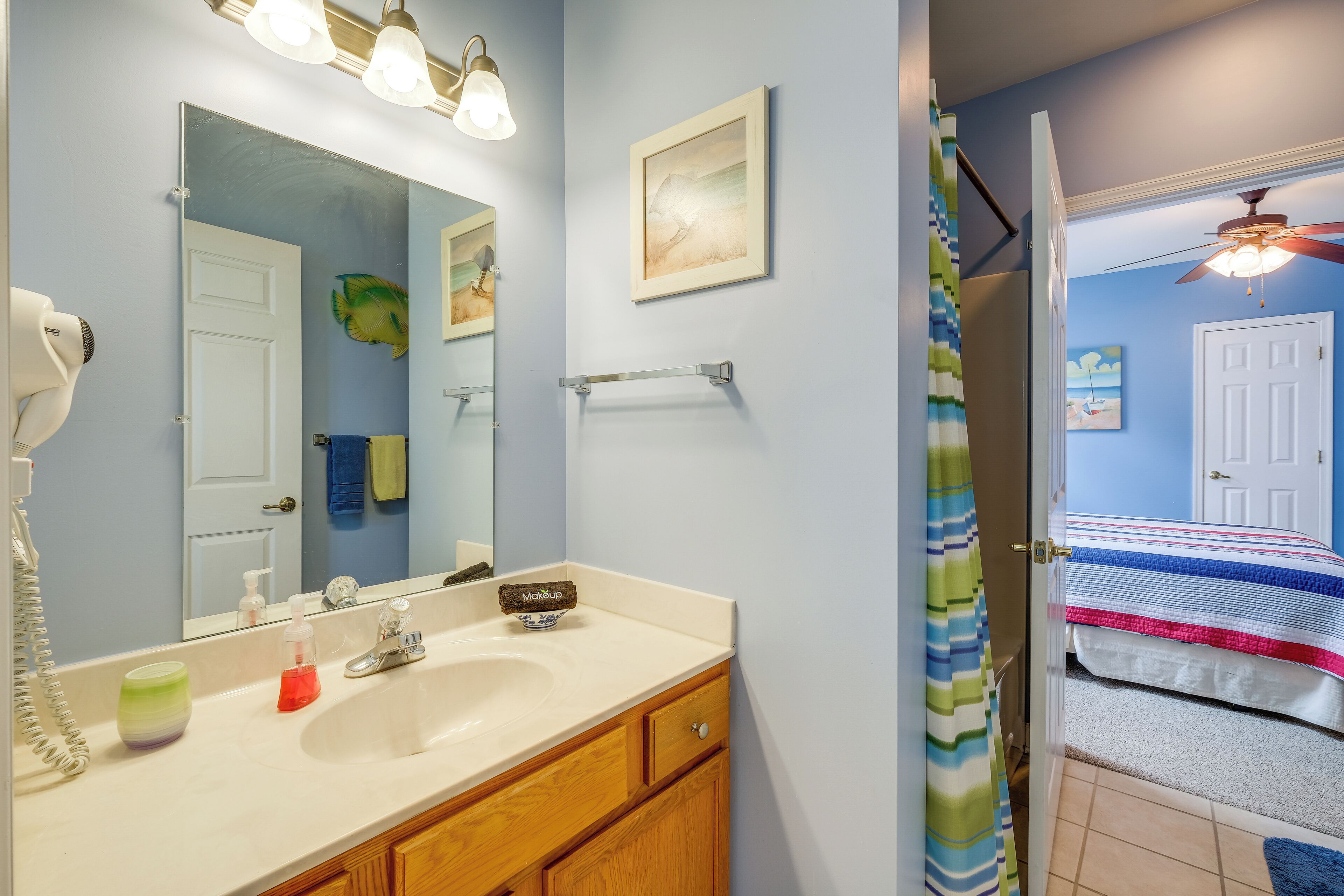 A bathroom with a sink, mirror, towel rack, and a shower curtain.