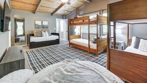 Ein Schlafzimmer mit Etagenbett, Schreibtisch und Deckenventilator.
