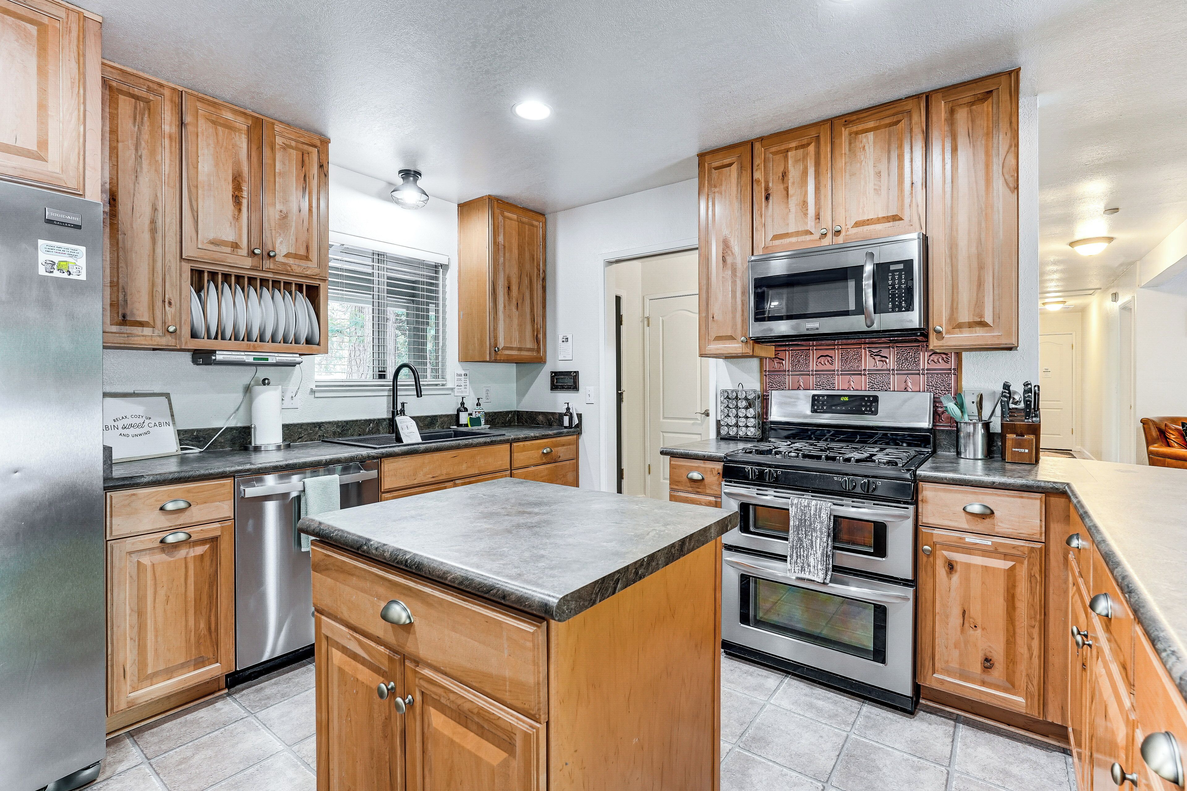 A kitchen with wooden cabinets, stainless steel appliances, and a granite countertop.