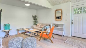 A cozy living room with a sofa, a coffee table, patterned ottomans, a wooden chair, a bookshelf, and a mirror on the wall. - Catskills Sanctuary w/ Lake Access + Hot Tub (Narrowsburg)
