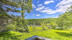A wooden deck overlooking a lush green landscape with a lake and forested hills. - Catskills Sanctuary w/ Lake Access + Hot Tub (Narrowsburg)