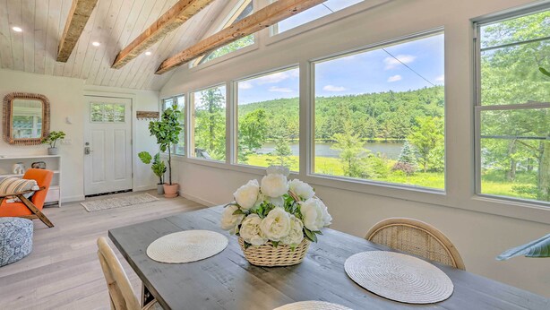 A spacious room with a high ceiling, large windows, and a wooden beam structure. - Catskills Sanctuary w/ Lake Access + Hot Tub (Narrowsburg)