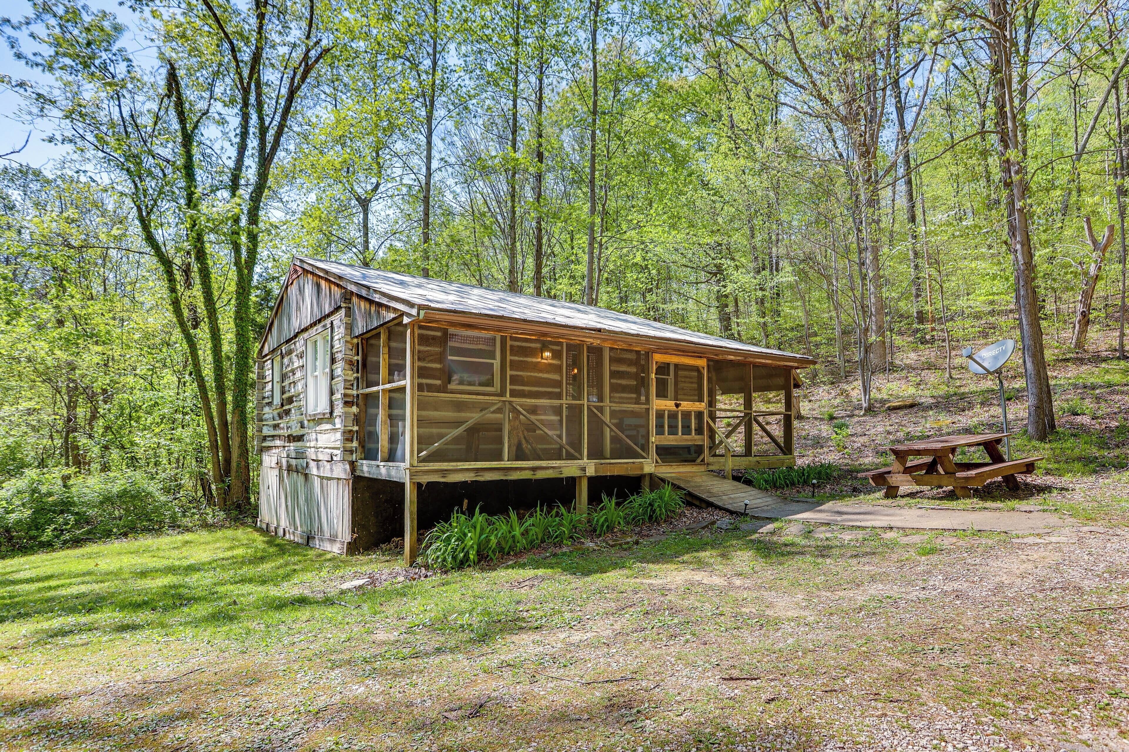 A rustic cabin with a wooden exterior, large windows, and a wooden deck.