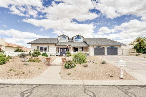 A two-story house with a front porch, a garage, and a landscaped front yard.