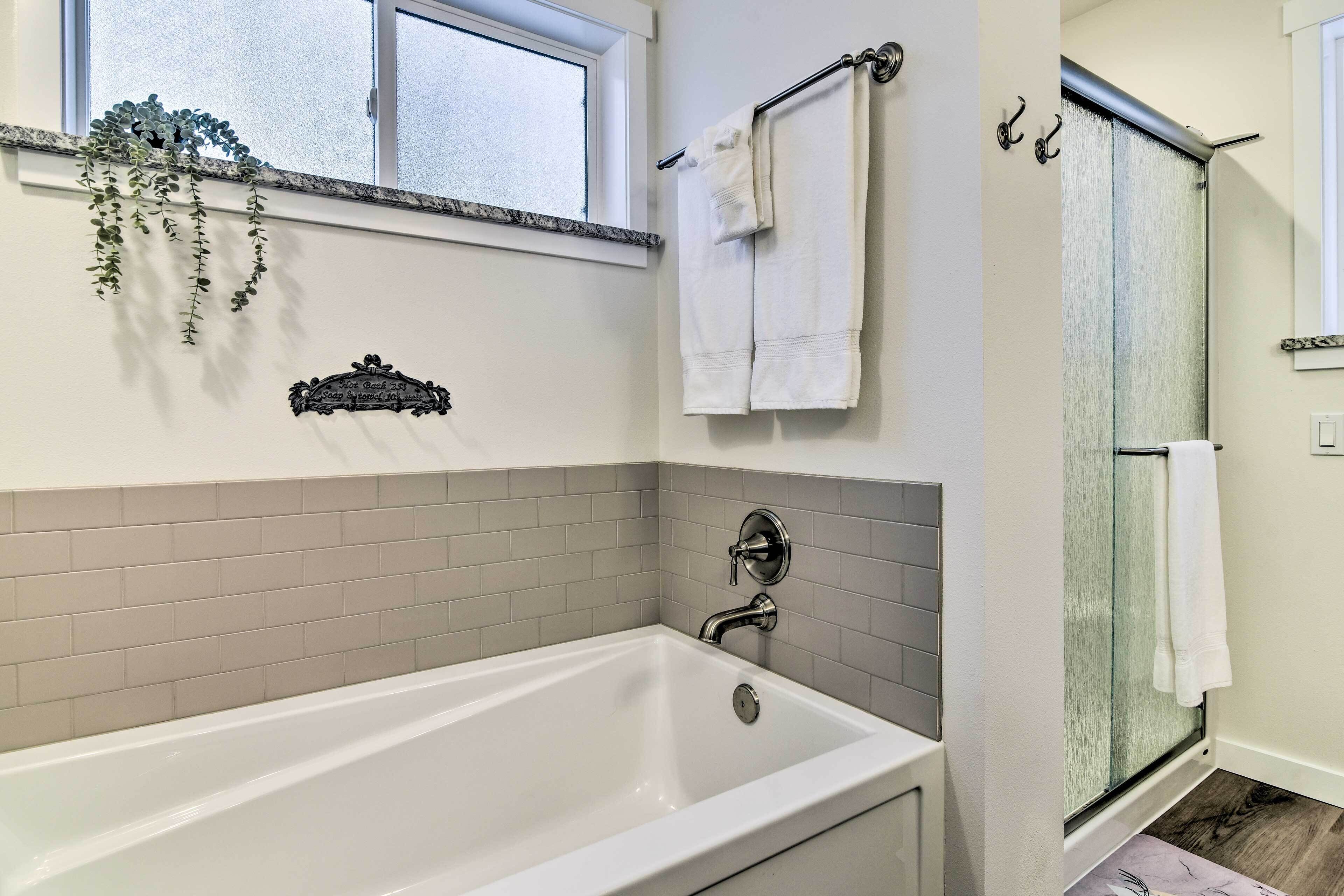 Un baño moderno con bañera, ducha y ventana.