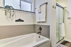 Un baño moderno con bañera, ducha y ventana.