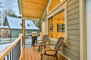 A wooden deck with Adirondack chairs and a grill, overlooking a snowy yard. - Family-friendly Packwood Retreat w/ Deck! (Packwood)