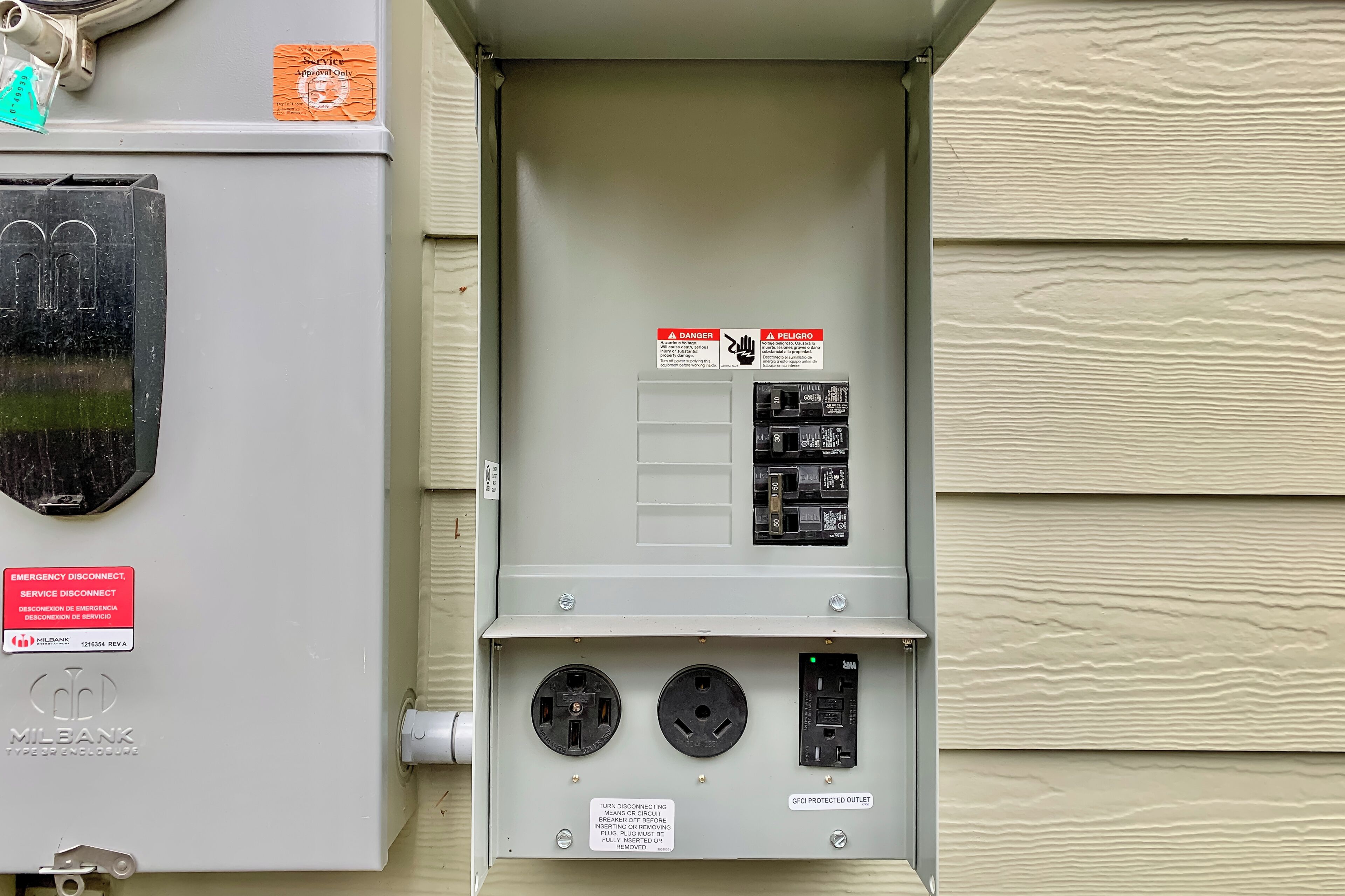 An electrical panel with multiple breakers and a warning sign.