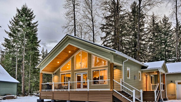 A cabin with a covered porch, large windows, and a staircase leading to the entrance. - Family-friendly Packwood Retreat w/ Deck! (Packwood)