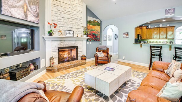A living room with a fireplace, leather sofas, a coffee table, and a television. - < 5 Mi to Lake Desoto: Grand Hot Springs Home (Hot Springs Village)