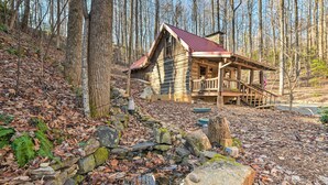 Une cabane rustique avec une façade en bois, une véranda et un toit en métal.