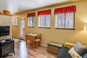 A living room with a wooden table and chairs, a television, and a sofa. - Sunriver Vacation Rental w/ Community Hot Tub! (Bend)