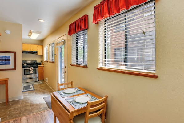 A kitchen with a dining area, featuring a table with chairs, a stove, and cabinets. - Sunriver Vacation Rental w/ Community Hot Tub! (Bend)