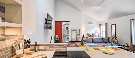 A modern kitchen with a central island, built-in appliances, and a dining area with a sofa and coffee table.