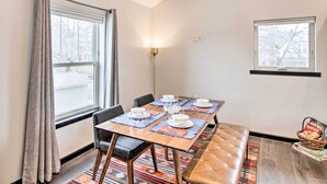 A dining area with a table set for four, a bench, and a lamp. - Contemporary-boho Loft in Downtown Livingston! (Livingston)