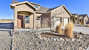 A modern house with a stone foundation, a sloped roof, and a front porch. - Modern Poncha Springs Townhome w/ Mtn Views! (Salida)