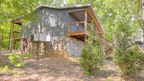 A rustic cabin with a stone foundation, wooden balcony, and a small attached shed. - Renovated Cabin w/ Decks, Views, & Fire Pit! (Pikeville)
