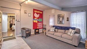 A cozy living room with a sofa, a fireplace, and a large banner on the wall. - Upstate New York Studio Rental - Pet Friendly (Stanley)