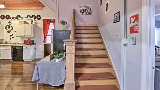 A staircase with a wooden handrail and a small table with a cloth at the bottom. - Upstate New York Studio Rental - Pet Friendly (Stanley)