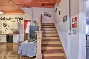 A staircase with a wooden handrail and a small table with a cloth at the bottom. - Upstate New York Studio Rental - Pet Friendly (Stanley)