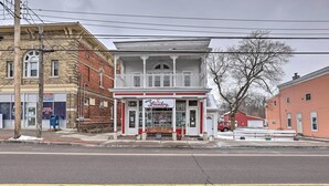 A two-story building with a balcony, a sign for 'GAYING Laundry', and a mailbox on the sidewalk. - Upstate New York Studio Rental - Pet Friendly (Stanley)