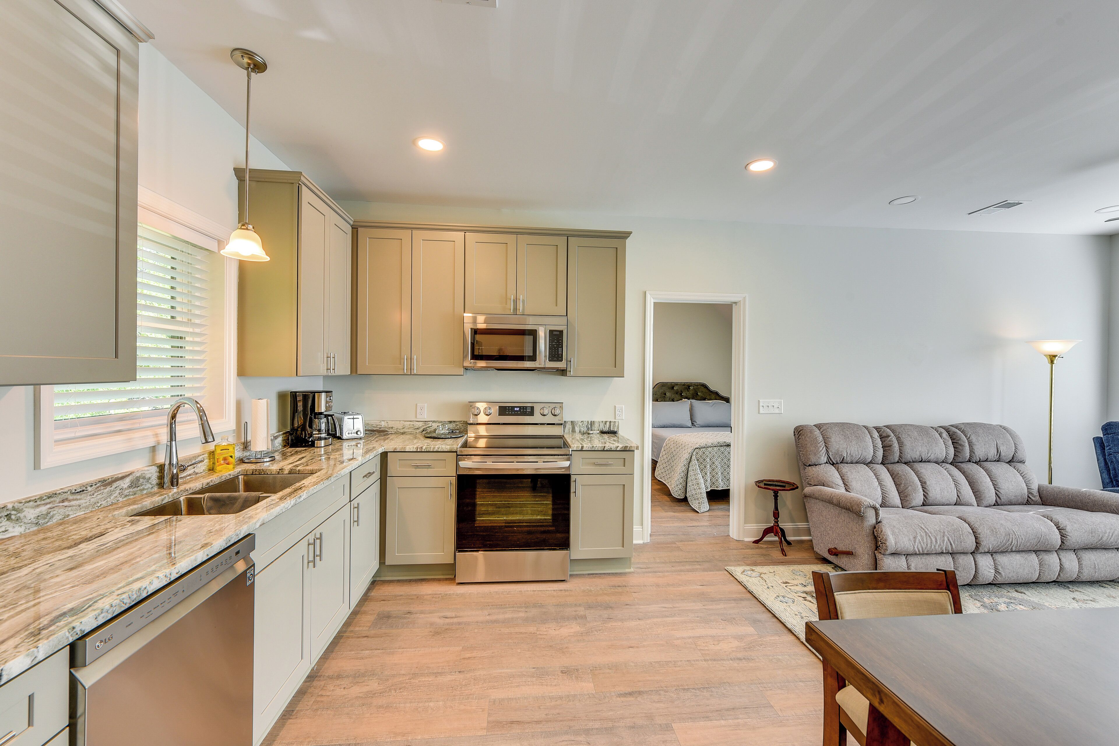A modern kitchen with a built-in oven, microwave, and stainless steel appliances. There is a dining area with a wooden table and chairs.
