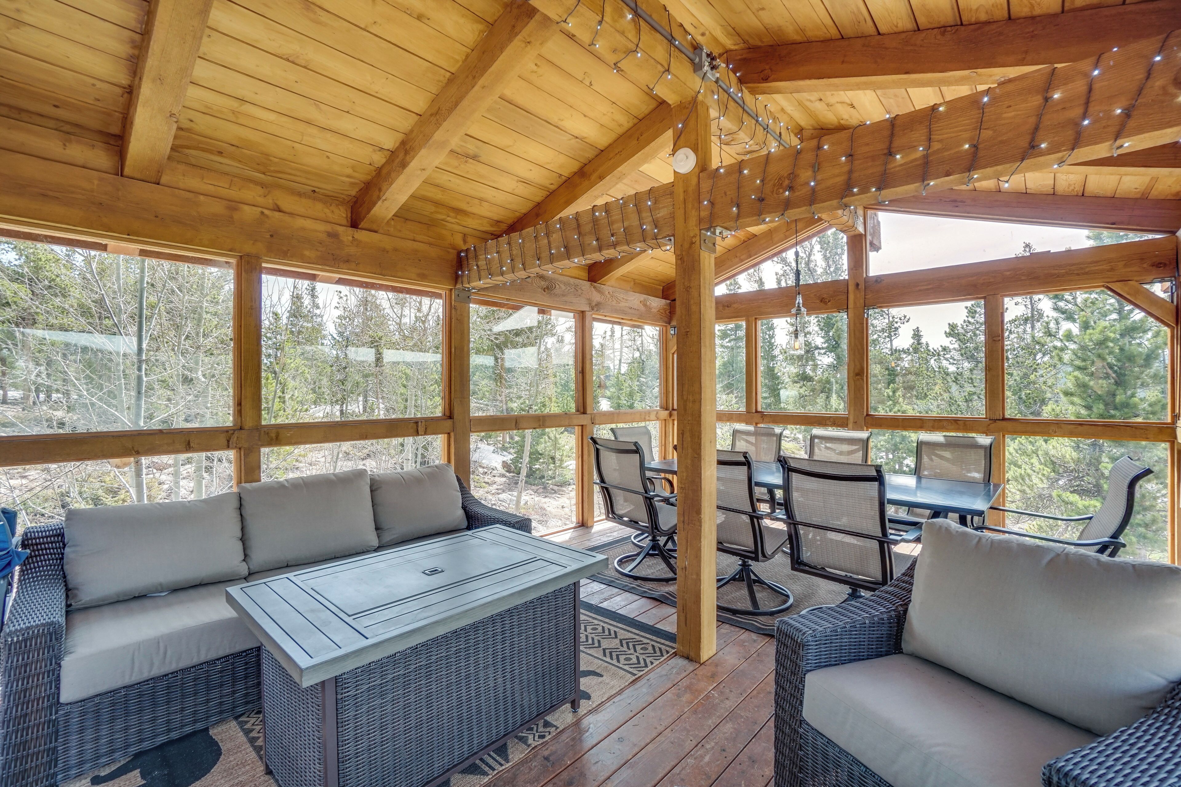 A covered outdoor seating area with wicker furniture and string lights.