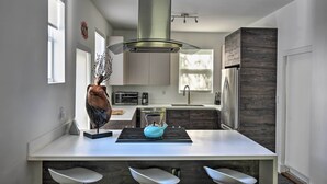A modern kitchen with a central island, stainless steel appliances, and a large window providing natural light. - Modern Miami Villa w/ Pool Oasis ~ 5 Mi to Beach! (North Miami)