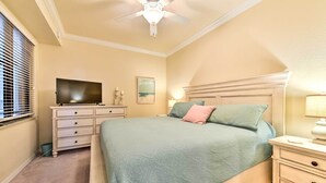 A bedroom with a bed, nightstands, a dresser, a ceiling fan, and a television. - Screened Patio & Resort Perks: Bradenton Condo! (Bradenton)