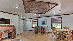 A spacious dining area with a wooden table and chairs, a kitchen in the background, and a decorative ceiling. - Lovely 'anna Fink House' w/ Patio & Fire Pit (Atoka)