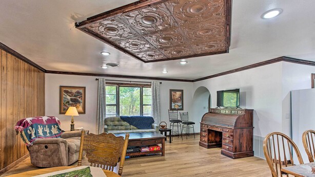 A cozy living room with a wooden ceiling, a sofa, a coffee table, and a dining table with chairs. - Lovely 'anna Fink House' w/ Patio & Fire Pit (Atoka)