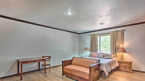 A bedroom with a bed, a wooden desk, a chair, a nightstand, and a lamp. - Lovely 'anna Fink House' w/ Patio & Fire Pit (Atoka)