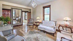 A spacious living room with a large mirror, a chandelier, and a white sofa. - Mtn View + Group Ready: Conifer Home on 100 Acres! (Conifer)