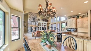 A spacious kitchen with wooden cabinets, a central island, and a chandelier.