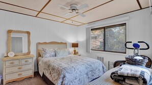 A bedroom with a bed, dresser, mirror, window, and ceiling fan. - Poconos Retreat w/ Pool and Lake Access (Lake Ariel)