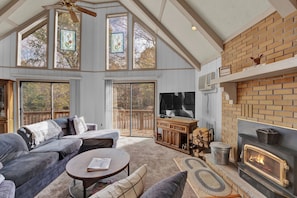 A spacious living room with a fireplace, a large TV, and a cozy seating area. - Poconos Retreat w/ Pool and Lake Access (Lake Ariel)