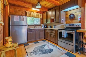 A wooden cabin kitchen with a refrigerator, stove, and wooden cabinets. - Rustic Fancy Gap Vacation Rental With Fire Pit (Fancy Gap)