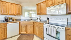 A kitchen with wooden cabinets, a dishwasher, a microwave, and an oven.