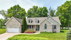 A two-story house with a brick facade, a front porch, and a garage.