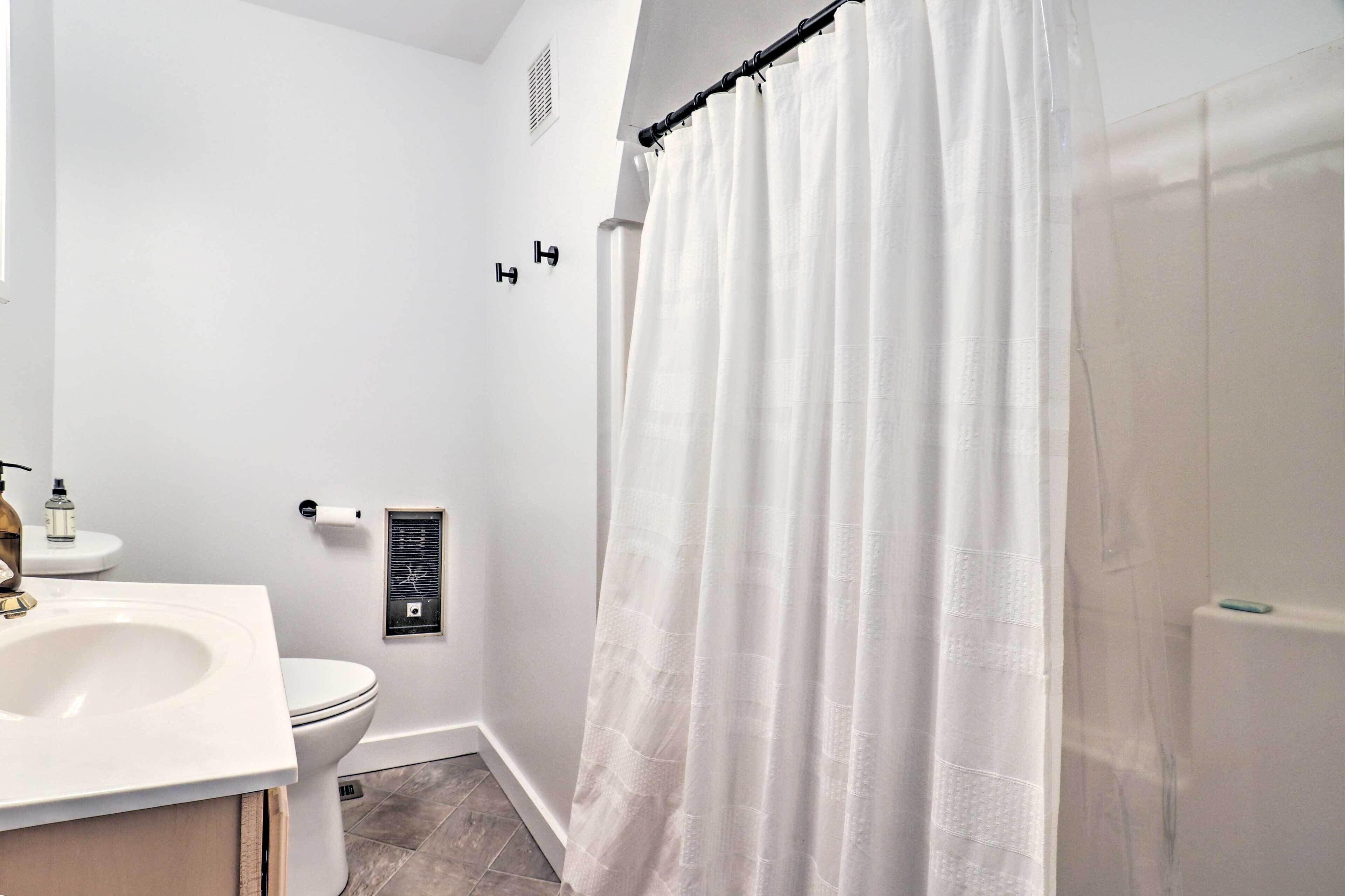 A bathroom with a white sink, toilet, and shower curtain.