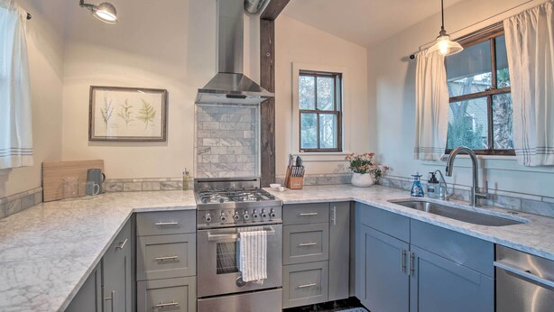 A modern kitchen with a built-in oven, stainless steel appliances, and a marble countertop. - Charming Family Cottage Close to San Antonio (Castroville)
